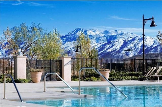 community pool featuring fence and a mountain view