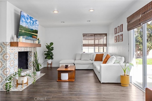 living area with a fireplace, baseboards, dark wood-style flooring, and recessed lighting