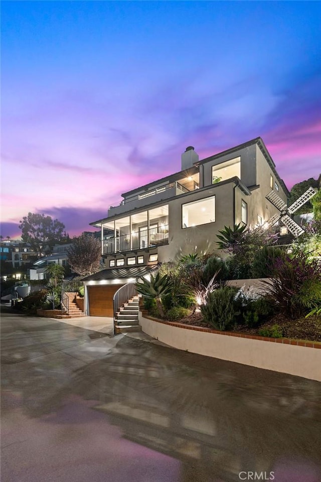 view of front of property with an attached garage, stairs, concrete driveway, and stucco siding