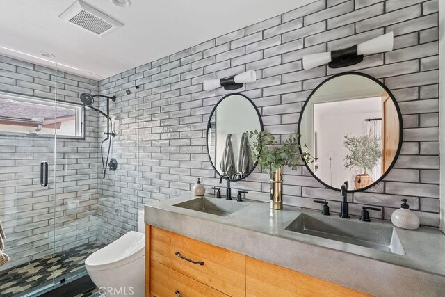 full bathroom featuring toilet, a sink, a stall shower, and visible vents