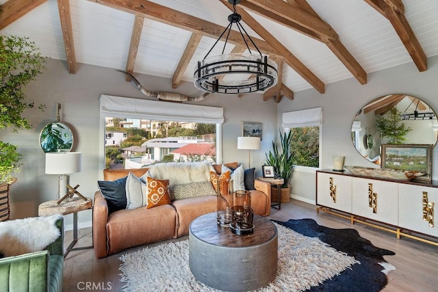 living area featuring baseboards, vaulted ceiling with beams, and wood finished floors