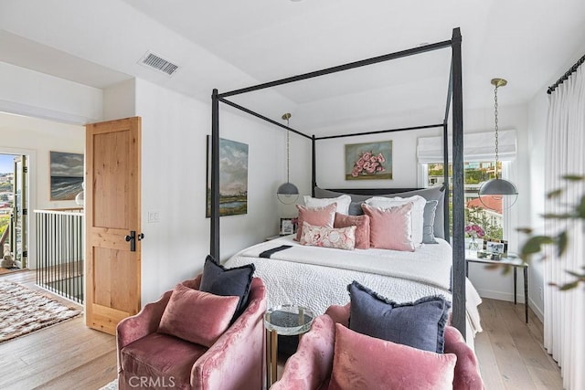 bedroom featuring wood finished floors and visible vents
