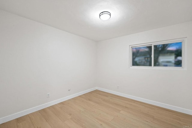 spare room with light wood finished floors and baseboards