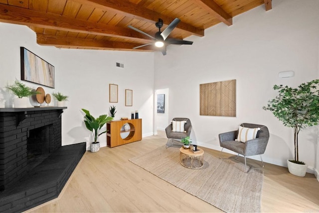 living area featuring wood ceiling, visible vents, a fireplace, and light wood finished floors