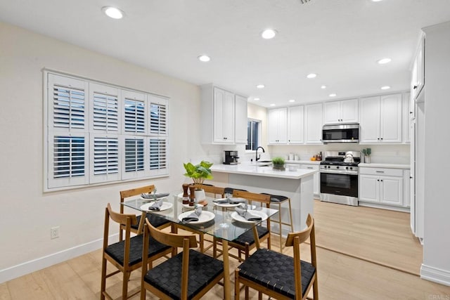 kitchen with appliances with stainless steel finishes, light countertops, white cabinetry, and a peninsula