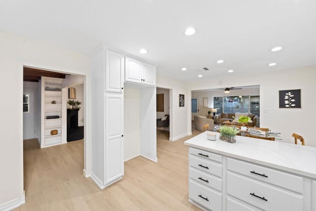 kitchen with open floor plan, light wood-style flooring, visible vents, and white cabinets