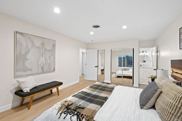 bedroom with light wood finished floors, baseboards, visible vents, multiple closets, and recessed lighting