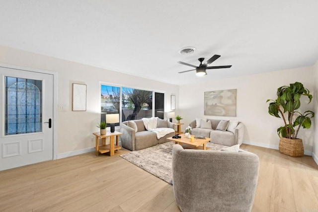 living area featuring a ceiling fan, light wood-style flooring, visible vents, and baseboards