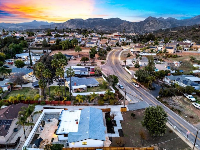 aerial view at dusk featuring a residential view and a mountain view