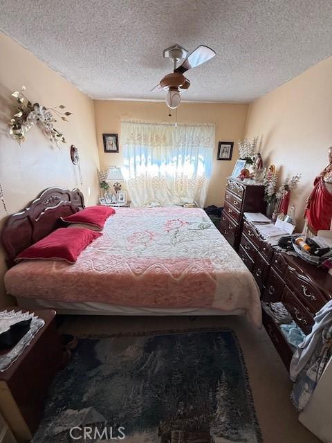 bedroom featuring ceiling fan and a textured ceiling