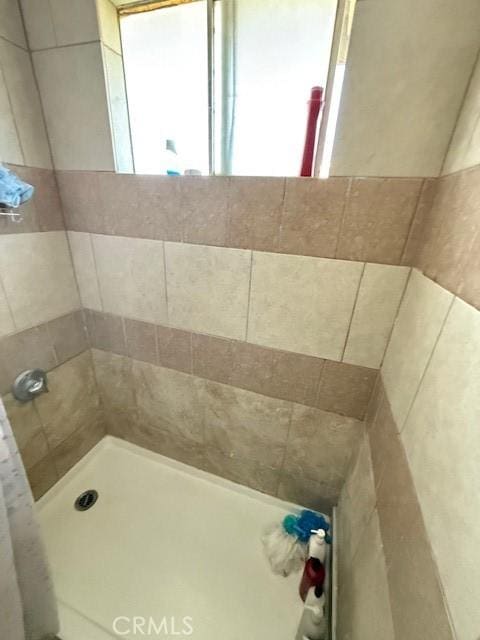 bathroom with tiled shower