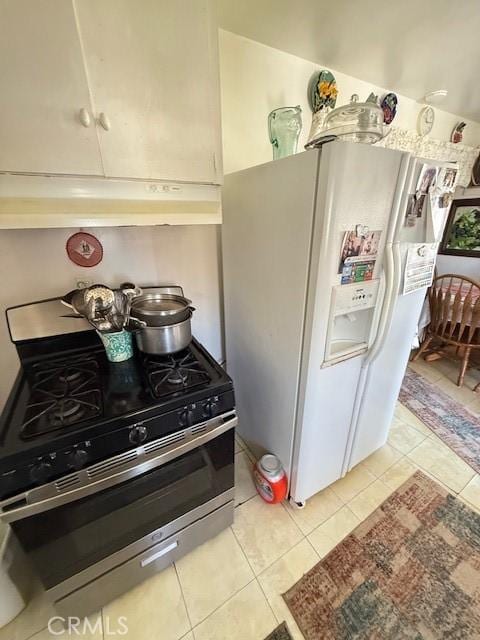 kitchen featuring gas stove, white refrigerator with ice dispenser, light tile patterned flooring, and under cabinet range hood