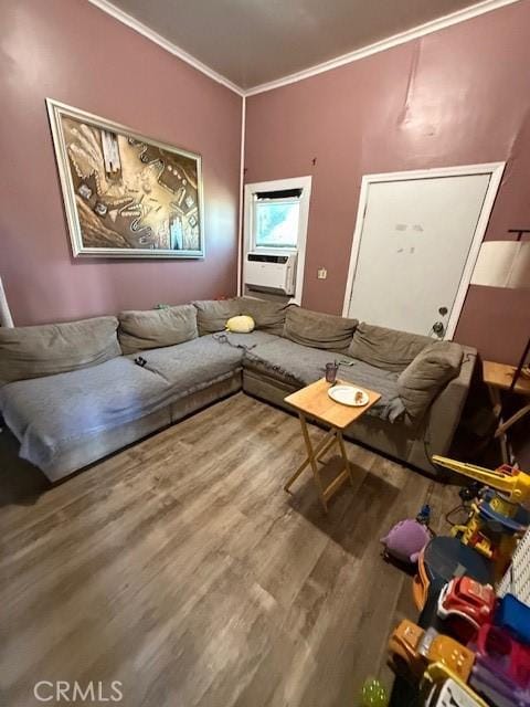 living room featuring cooling unit, wood finished floors, and crown molding