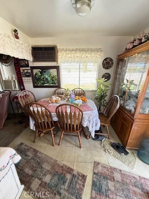 dining room featuring an AC wall unit and tile patterned floors