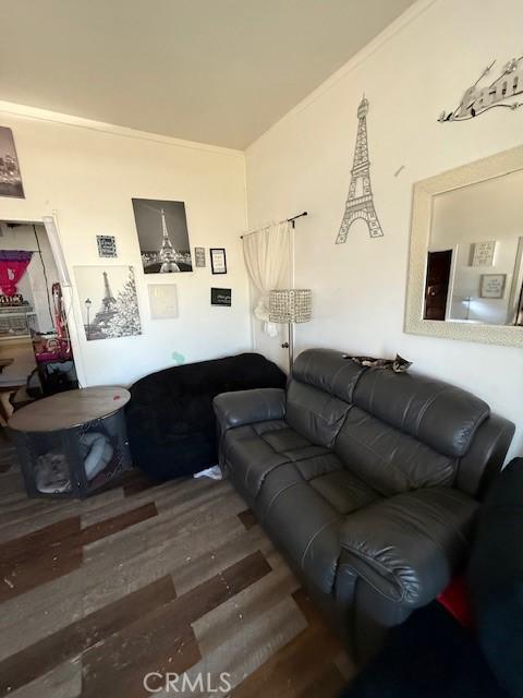 living area with crown molding and wood finished floors