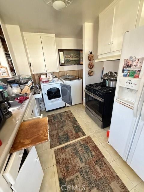 kitchen with light tile patterned floors, under cabinet range hood, white refrigerator with ice dispenser, white cabinetry, and stainless steel gas stove