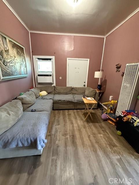 living area featuring crown molding, cooling unit, and wood finished floors