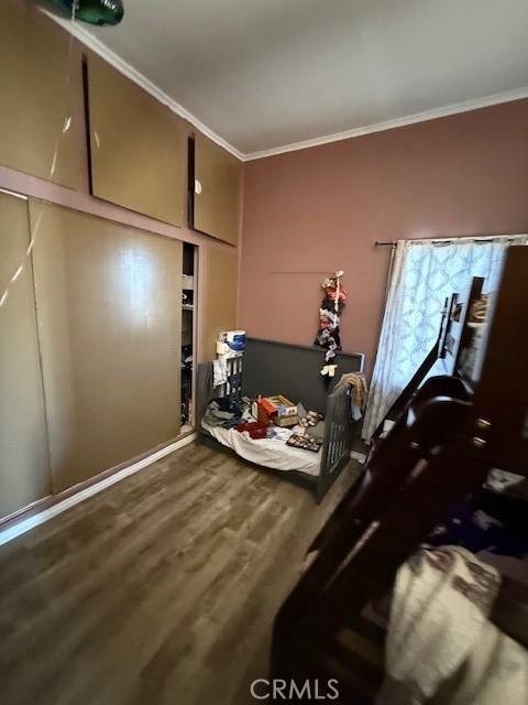 bedroom with dark wood-type flooring and crown molding