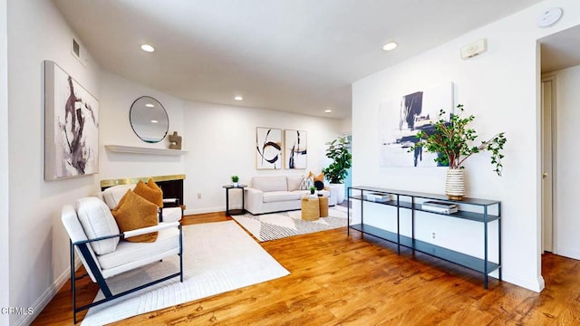 sitting room featuring recessed lighting, visible vents, a fireplace, and wood finished floors