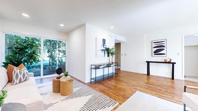 living room featuring baseboards, wood finished floors, and recessed lighting