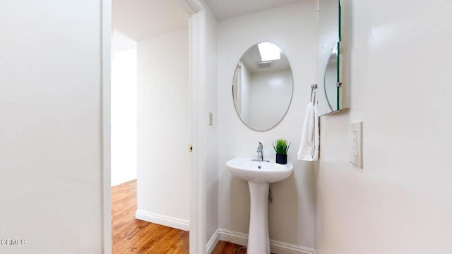 bathroom with visible vents, baseboards, and wood finished floors