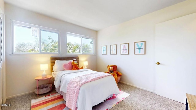 bedroom with light colored carpet and baseboards