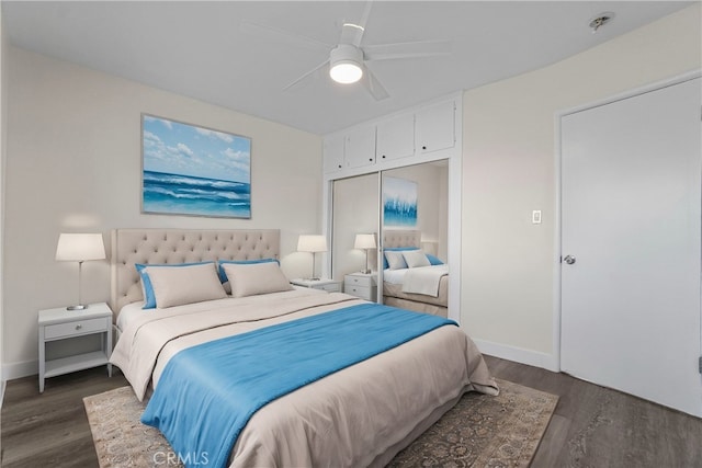 bedroom featuring a closet, baseboards, dark wood finished floors, and a ceiling fan