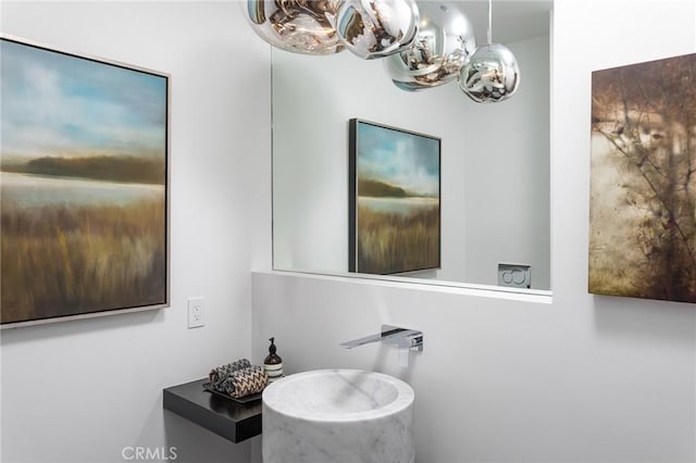 bathroom with a sink and an inviting chandelier