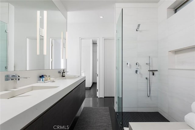 full bathroom featuring a sink, double vanity, a shower stall, and tile patterned flooring