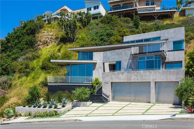 contemporary house featuring stairs, a garage, and stucco siding