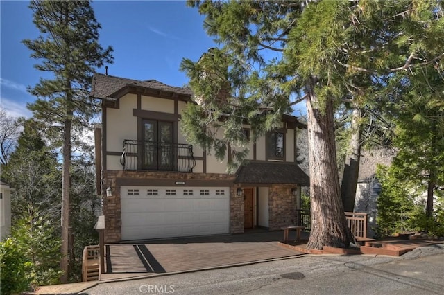 view of front of property featuring stucco siding, stone siding, and an attached garage