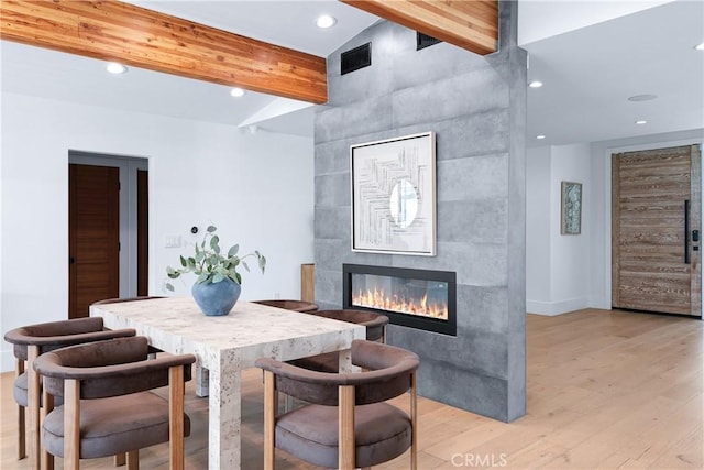 dining room featuring light wood finished floors, recessed lighting, visible vents, a tiled fireplace, and baseboards