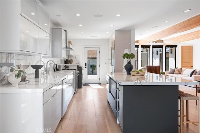 kitchen featuring stainless steel stove, white cabinets, backsplash, a center island, and modern cabinets