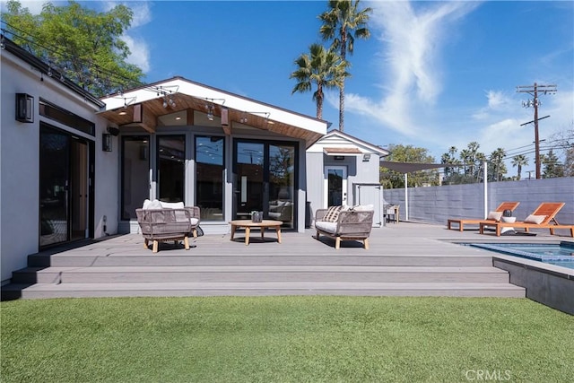 back of house with a fenced in pool, fence, a deck, and a lawn