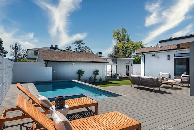 rear view of house with an outdoor hangout area, a deck, fence, and a fenced in pool