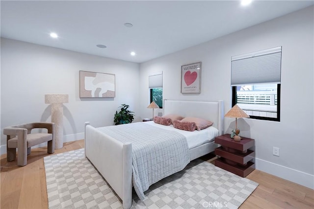 bedroom with baseboards, light wood-type flooring, and recessed lighting