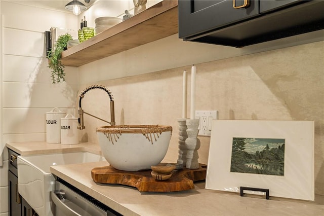 interior details with light countertops, stainless steel dishwasher, and open shelves