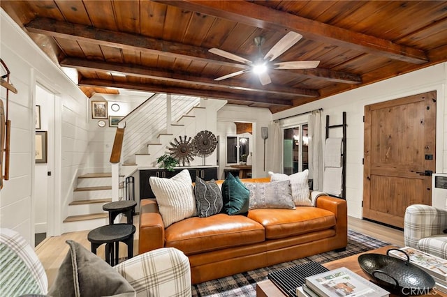 living area with ceiling fan, wooden ceiling, wood finished floors, stairway, and beamed ceiling