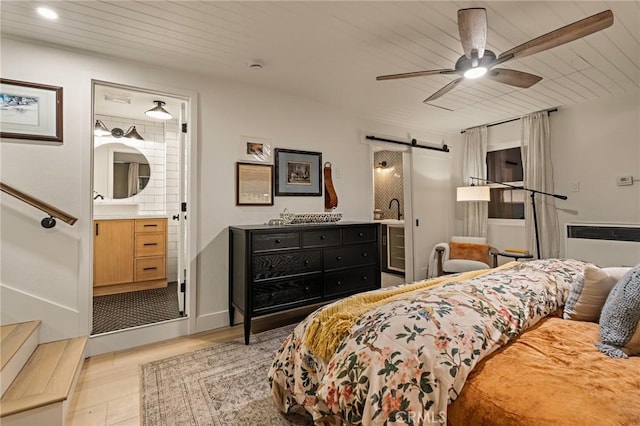 bedroom featuring a barn door, ensuite bath, wood ceiling, and radiator