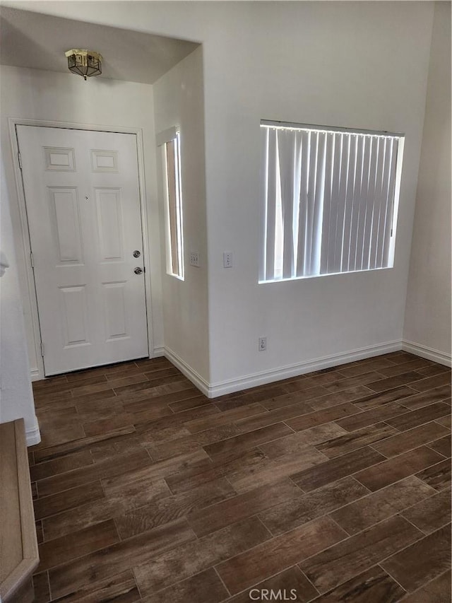 foyer with dark wood finished floors and baseboards