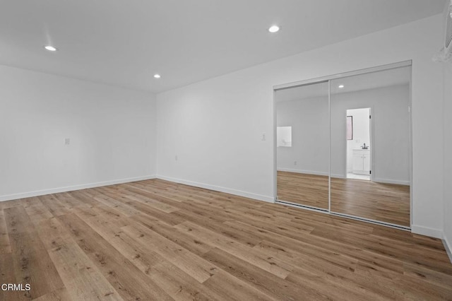 unfurnished room with light wood-style floors, recessed lighting, and baseboards