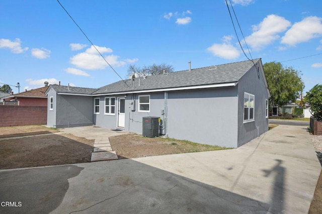 rear view of property featuring cooling unit, a patio area, fence, and stucco siding