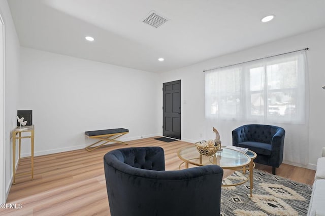 living area with light wood-type flooring, visible vents, and recessed lighting