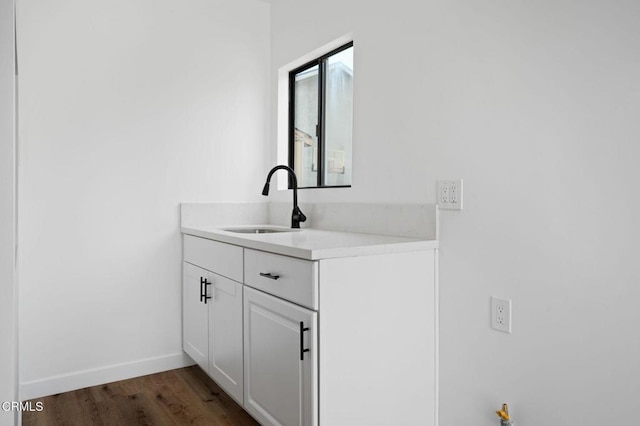 bathroom featuring vanity, baseboards, and wood finished floors