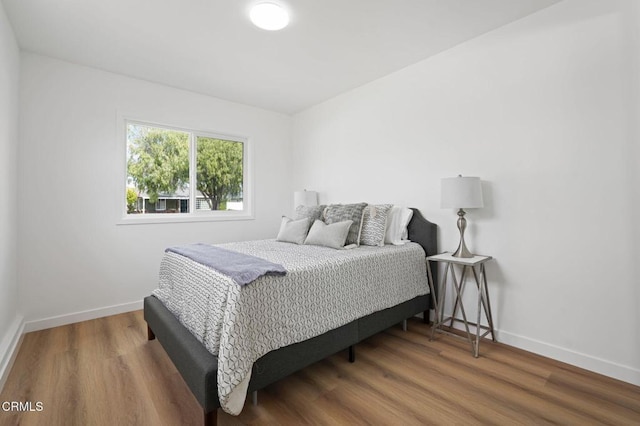 bedroom featuring baseboards and wood finished floors