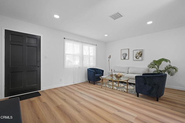 living area with light wood-style floors, baseboards, visible vents, and recessed lighting