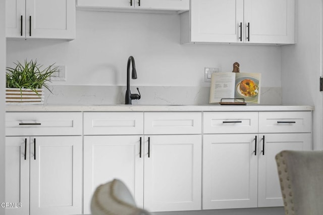 kitchen featuring white cabinets and light stone countertops