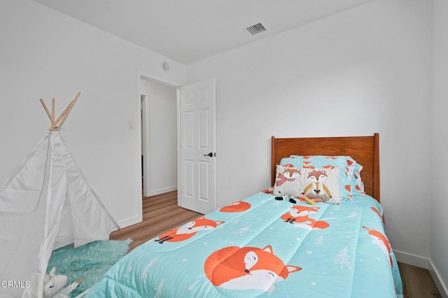 bedroom with visible vents, light wood-style flooring, and baseboards