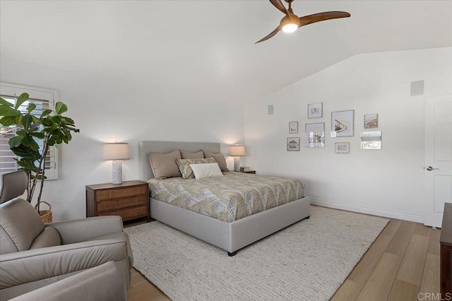 bedroom with vaulted ceiling, wood finished floors, a ceiling fan, and baseboards