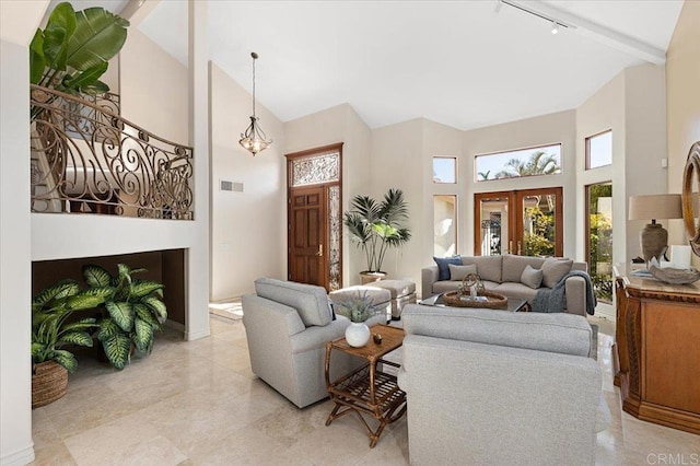 living room with high vaulted ceiling, rail lighting, visible vents, and baseboards